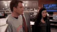 a man and a woman are standing next to each other in a room .