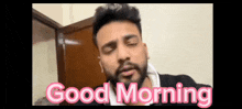 a man with his eyes closed and the words good morning behind him
