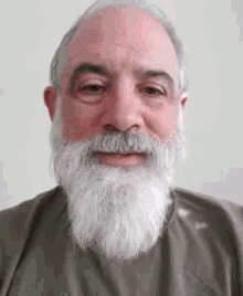 a man with a beard is smiling for the camera .