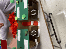 a cardboard model of a forest with trees and a recycle sign