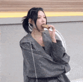 a woman wearing a plaid jacket is eating a piece of food