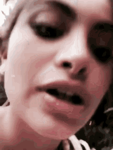a close up of a woman 's face with her mouth open and her teeth showing .
