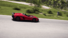 a red sports car driving down a road