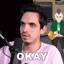 a man in front of a microphone with okay written on his shirt