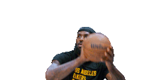 a man wearing a lakers basketball shirt is shooting a basketball