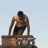a man is kneeling down in front of a scoreboard that says all star 7 9