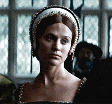 a woman wearing a headpiece with pearls and beads on it
