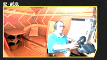 a man wearing headphones is driving a truck with the number 92-wojol on the bottom right