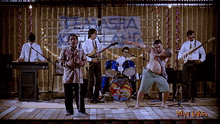 a group of men are playing instruments in front of a sign that says ' tenda '
