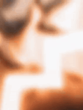 a blurry image of a person sitting at a table with a laptop .