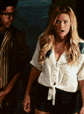 a man and a woman are standing next to each other and the woman has a surprised look on her face