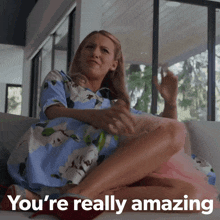 a woman sitting on a couch with the words you 're really amazing written below her