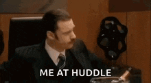 a group of people are sitting around a table with the words `` me at huddle '' written on the bottom .