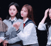 a group of girls are posing for a picture and one of them is wearing a sailor suit