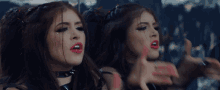 a woman with red lipstick is looking at herself in the mirror