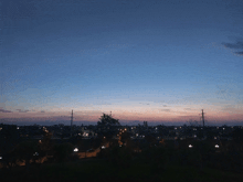a sunset over a city with a few lights on