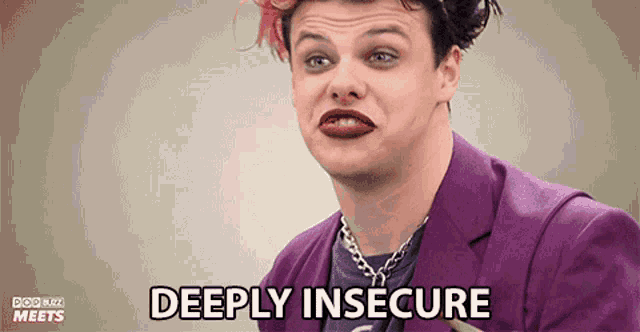 a man in a purple suit is making a face and says deeply insecure