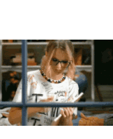 a woman wearing glasses is reading a book while wearing a shirt that says t.