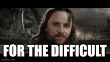 a man with long hair and a beard is looking at the camera with the words `` for the difficult '' above him .