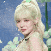 a woman with blonde hair and green eyes is wearing a green shirt
