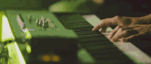 a close up of a person playing a keyboard with a green background