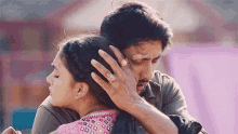 a man with a ring on his finger holds a woman in his arms