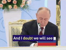 a man sitting at a table with a sign that says and i doubt we will see on it