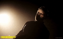 a man in a dark room with the word thunderbolts on the bottom right