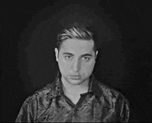 a black and white photo of a man with a floral shirt