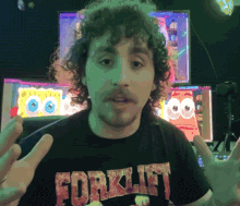 a man with curly hair wears a shirt that says forklift on it