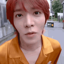 a close up of a person 's face with a sign in the background that says exit