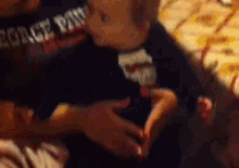a person is holding a baby in their arms and the baby is wearing a shirt that says force paw