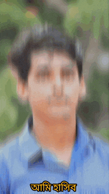 a young man in a blue shirt is looking at the camera with a foreign language written above him