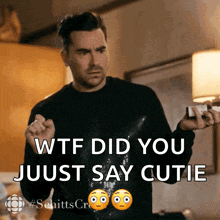 a man in a black sweater is holding a bottle and says wtf did you just say cutie