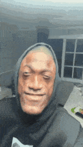 a man wearing a hoodie is making a funny face while looking at the camera .