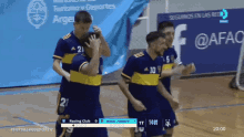 a group of soccer players are celebrating in front of a banner that says @afac