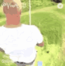 a person is sitting on a swing in a field .