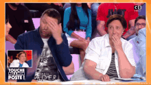 a man wearing a darth vader shirt covers his face while a woman covers her mouth