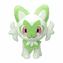 a green and white stuffed animal with wings and pink eyes