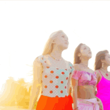 three women are standing in a line with their arms outstretched looking up