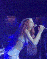 a woman singing into a microphone on a stage