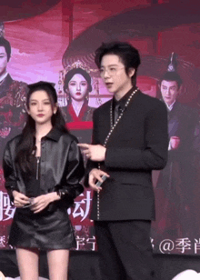 a man and a woman are standing next to each other in front of a poster for a movie