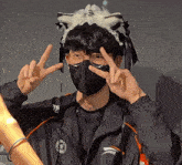 a person wearing a black mask and a jacket that says adidas on the front