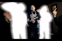 a man in a black shirt is standing in front of a group of people .