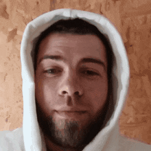 a man with a beard wearing a white hooded sweatshirt