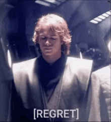 a man in a star wars costume is standing in a dark room with his eyes closed and the word regret on the bottom .