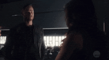 a man and a woman are standing next to each other in a dark room .