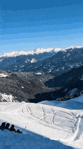 a group of people sitting on top of a snow covered slope
