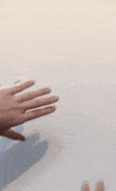 a person 's hands are reaching out to touch each other