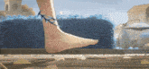 a woman 's foot with spikes on it is walking on a wooden surface